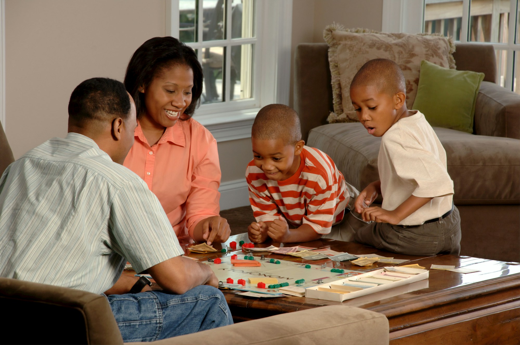 A family playing a board game at a sunlit table