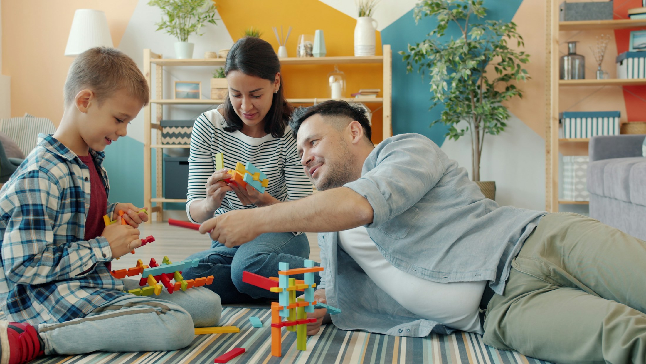 A family building with colorful blocks together on the living room floor